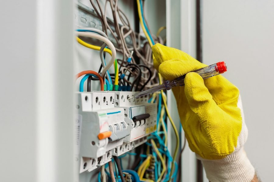 Electrician verifying circuits with test equipment during an electrical inspection